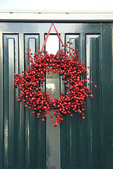 Image showing Berry christmas wreath with decorations on a door