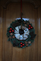 Image showing Classic christmas wreath with decorations on a door