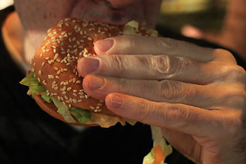 Image showing Man holding a hamburger