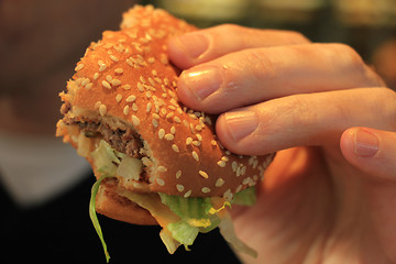 Image showing Man holding a hamburger