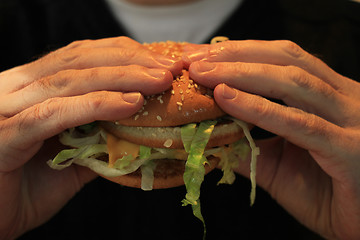 Image showing Man holding a hamburger