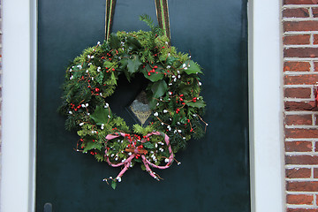 Image showing Classic christmas wreath with decorations on a door