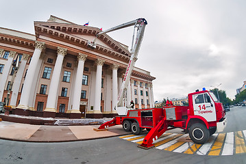 Image showing Builders paint building facade by fire truck