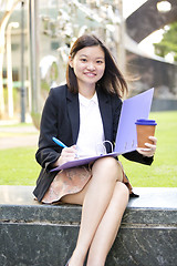 Image showing Young female Asian business executive holding file