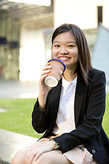 Image showing Young female Asian executive drinking coffee