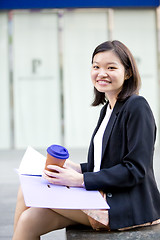 Image showing Young female Asian business executive holding file