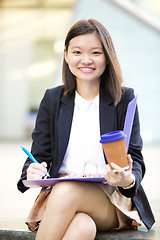 Image showing Young female Asian business executive holding file