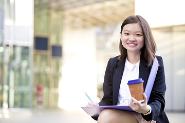 Image showing Young female Asian business executive holding file