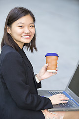 Image showing Young Asian female business executive using laptop