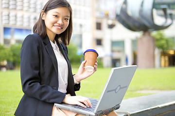 Image showing Young Asian female business executive using laptop