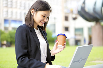 Image showing Young Asian female business executive using laptop