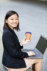 Image showing Young Asian female business executive using laptop