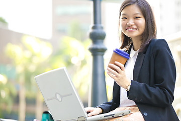 Image showing Young Asian female business executive using laptop