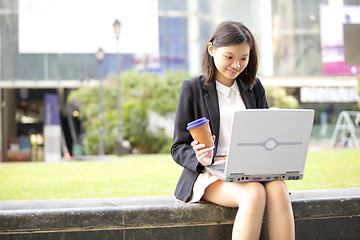 Image showing Young Asian female business executive using laptop