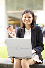 Image showing Young Asian female business executive using laptop