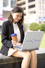 Image showing Young Asian female business executive using laptop