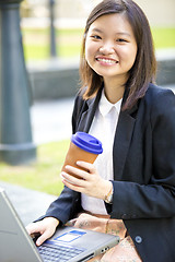Image showing Young Asian female business executive using laptop