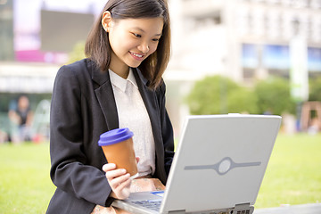 Image showing Young Asian female business executive using laptop