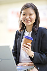 Image showing Young Asian female business executive using laptop