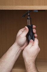 Image showing Hands with a screwdriver