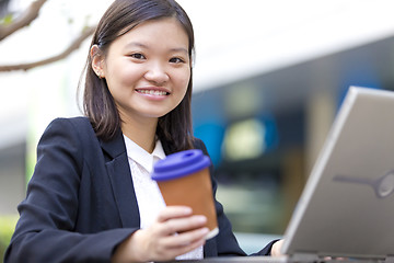 Image showing Young Asian female business executive using laptop