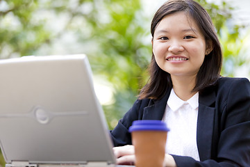 Image showing Young Asian female business executive using laptop