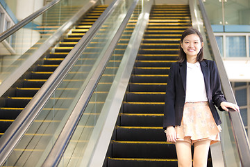 Image showing Young Asian female business executive on escalator