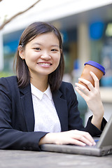 Image showing Young Asian female business executive using laptop