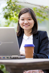 Image showing Young Asian female business executive using laptop