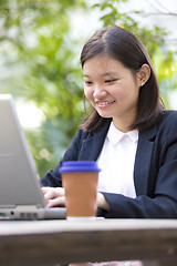 Image showing Young Asian female business executive using laptop