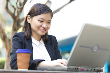 Image showing Young Asian female business executive using laptop