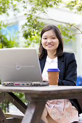 Image showing Young Asian female business executive using laptop