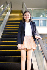 Image showing Young Asian female business executive on escalator