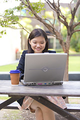 Image showing Young Asian female business executive using laptop