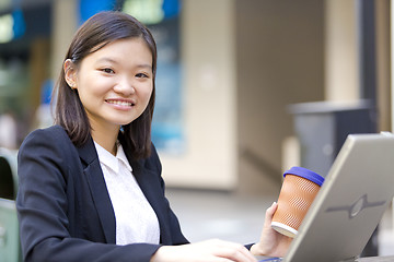 Image showing Young Asian female business executive using laptop