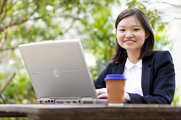 Image showing Young Asian female business executive using laptop