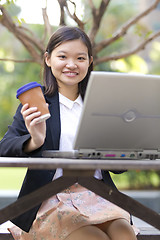 Image showing Young Asian female business executive using laptop