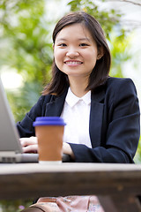 Image showing Young Asian female business executive using laptop