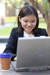 Image showing Young Asian female business executive using laptop