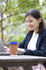 Image showing Young Asian female business executive using laptop