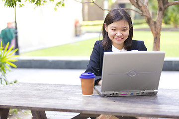 Image showing Young Asian female business executive using laptop