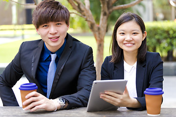 Image showing Young Asian female and male business executive using tablet