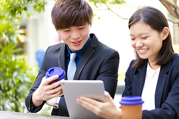 Image showing Young Asian female and male business executive using tablet