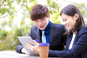 Image showing Young Asian female and male business executive using tablet