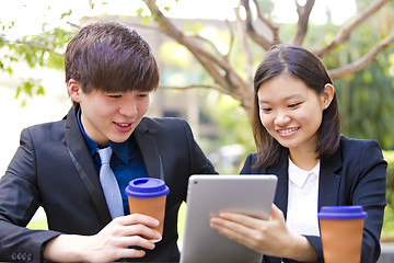 Image showing Young Asian female and male business executive using tablet