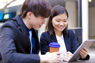 Image showing Young Asian female and male business executive using tablet