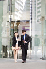 Image showing Young Asian female and male business executive walking together