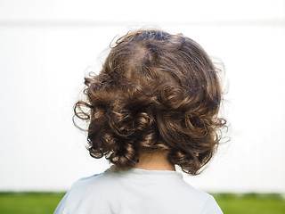 Image showing Little caucasian person with curly hair staring at watching a wh