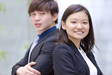 Image showing Young Asian female and male business executive smiling portrait