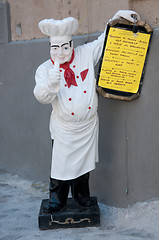 Image showing Statue of chef holding a menu of a restaurant